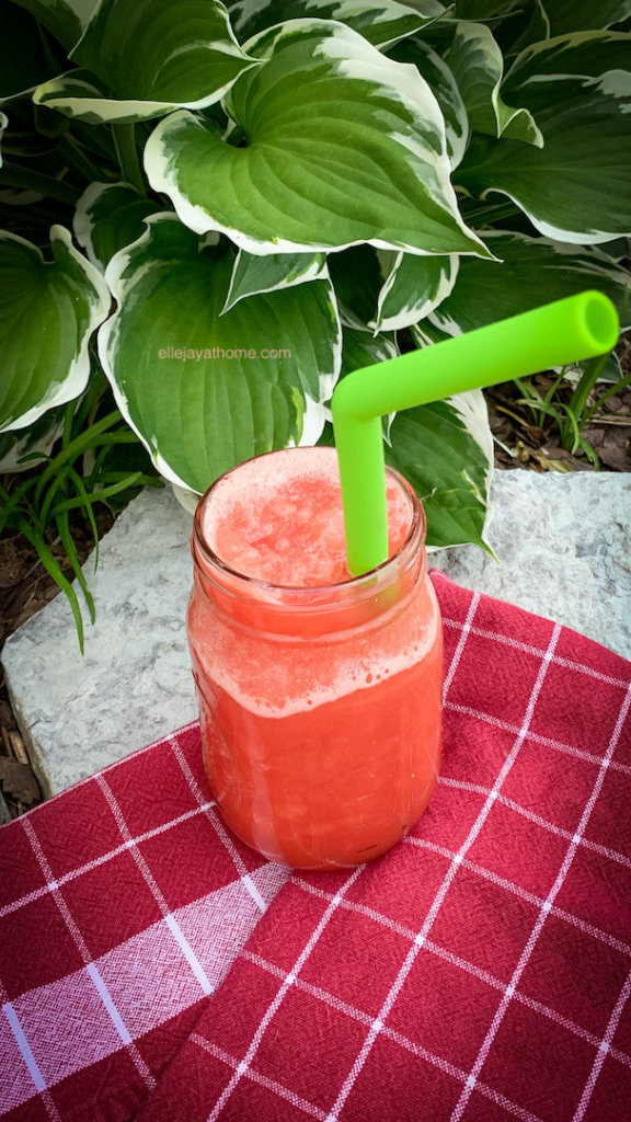 Frozen watermelon lemonade in a Ball jar, hostas, a picnic blanket, and a green silicone straw