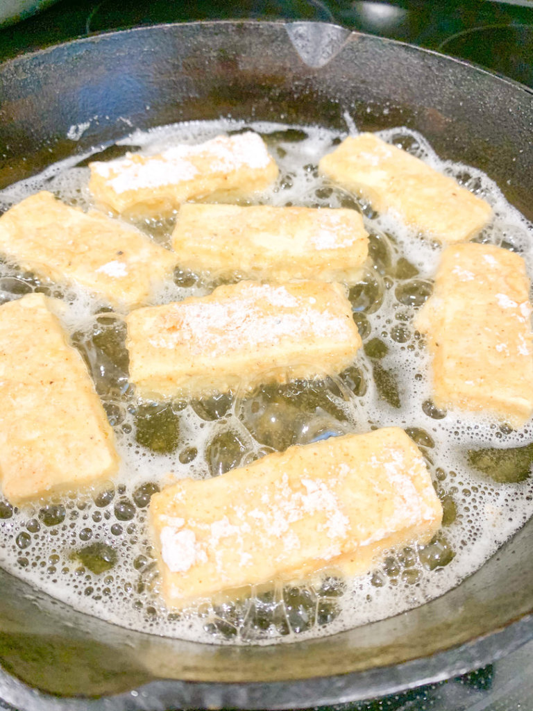 Chicken Fried Tofu in a cast-iron skillet with vegetable oil