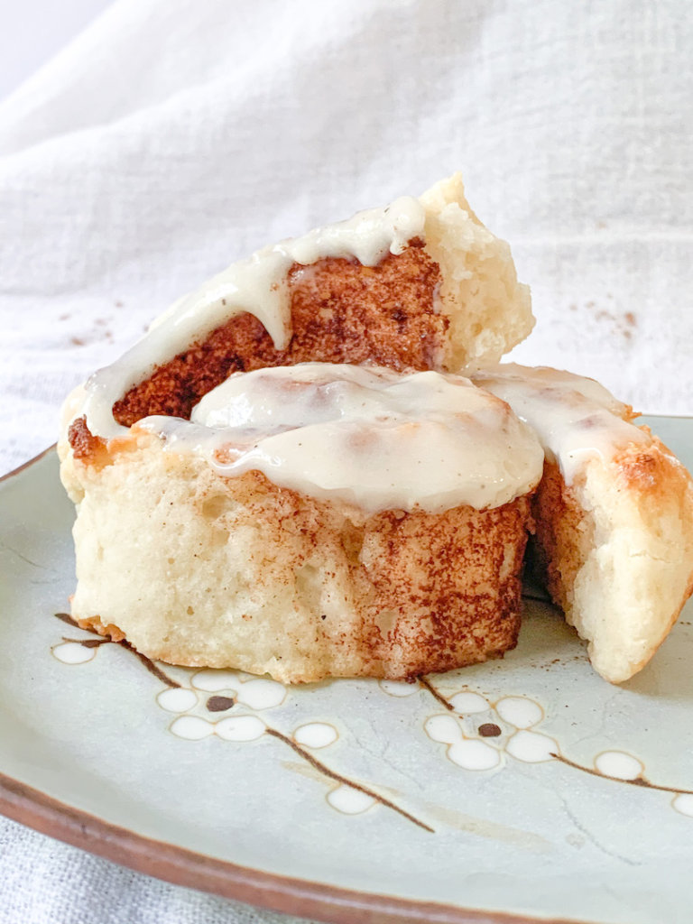 2 ingredient dough cinnamon rolls with swirl exposed and frosting dripping down