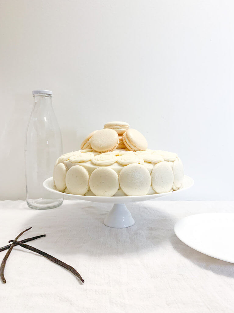 Vanilla bean cake with cream cheese frosting decorated with vanilla bean macarons