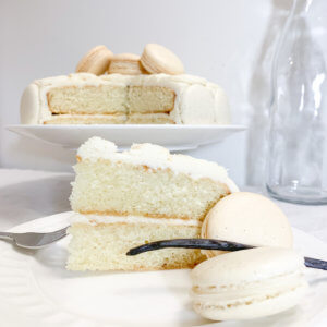 slice of vanilla bean cake with macarons on a plate