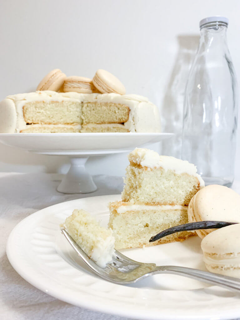Slice of vanilla bean cake with a bite on a fork.