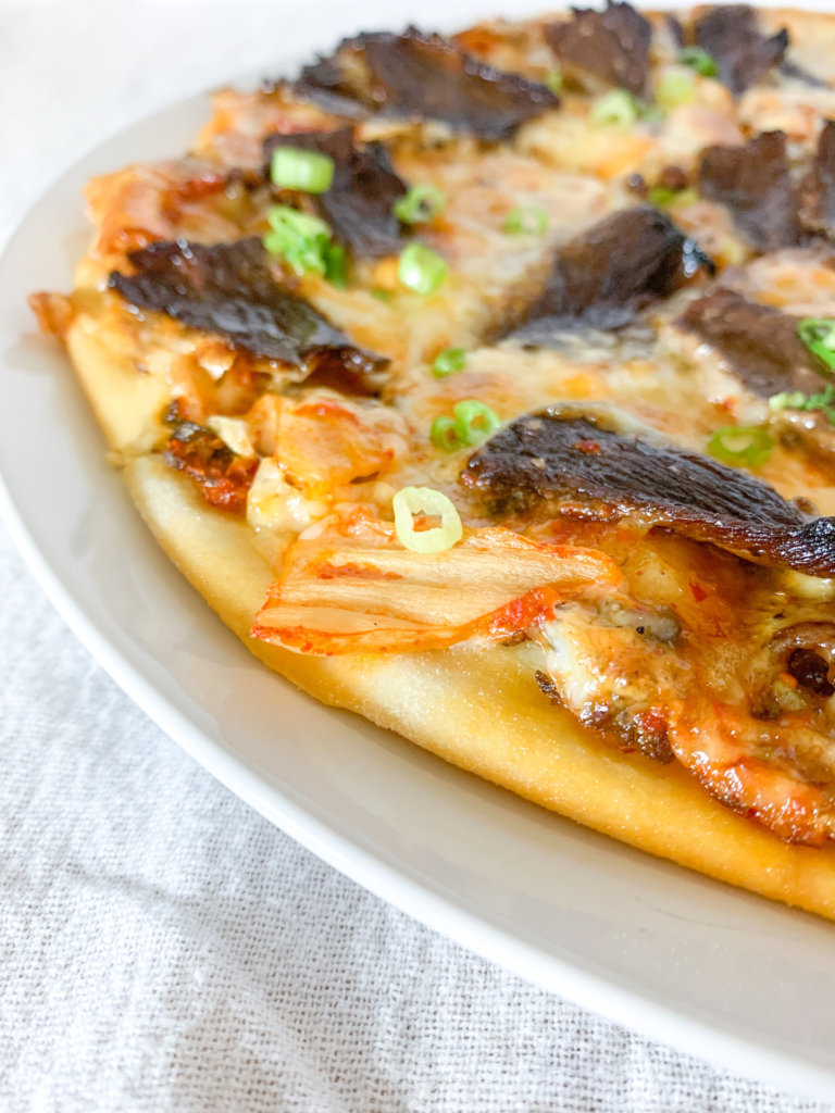 kimchi on a pizza with beef bulgogi and green onion