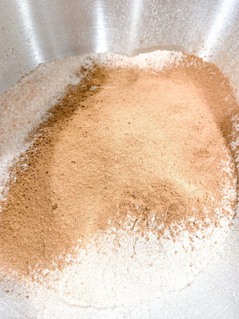 All purpose flour, rye flour, wheat flour, and cocoa powder in a mixing bowl.