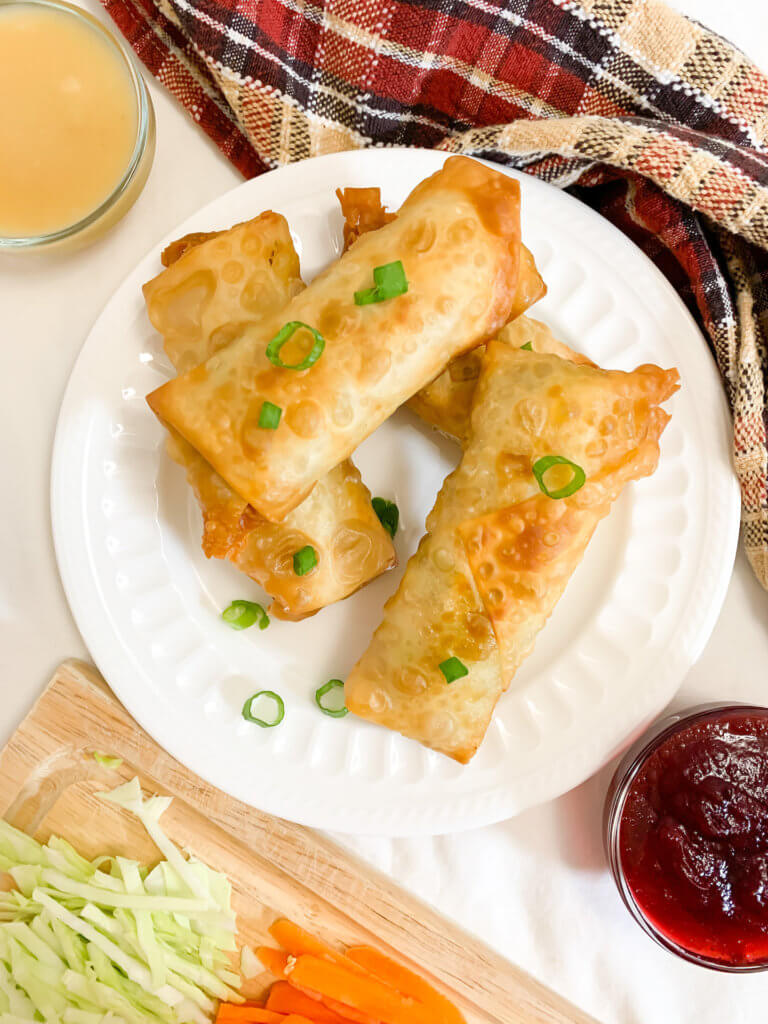 Thanksgiving leftover egg rolls on a plate with cranberry and gravy dipping sauces