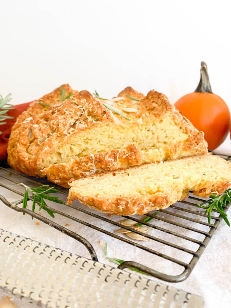 Front view of sliced pumpkin soda bread with rosemary and grated asiago.