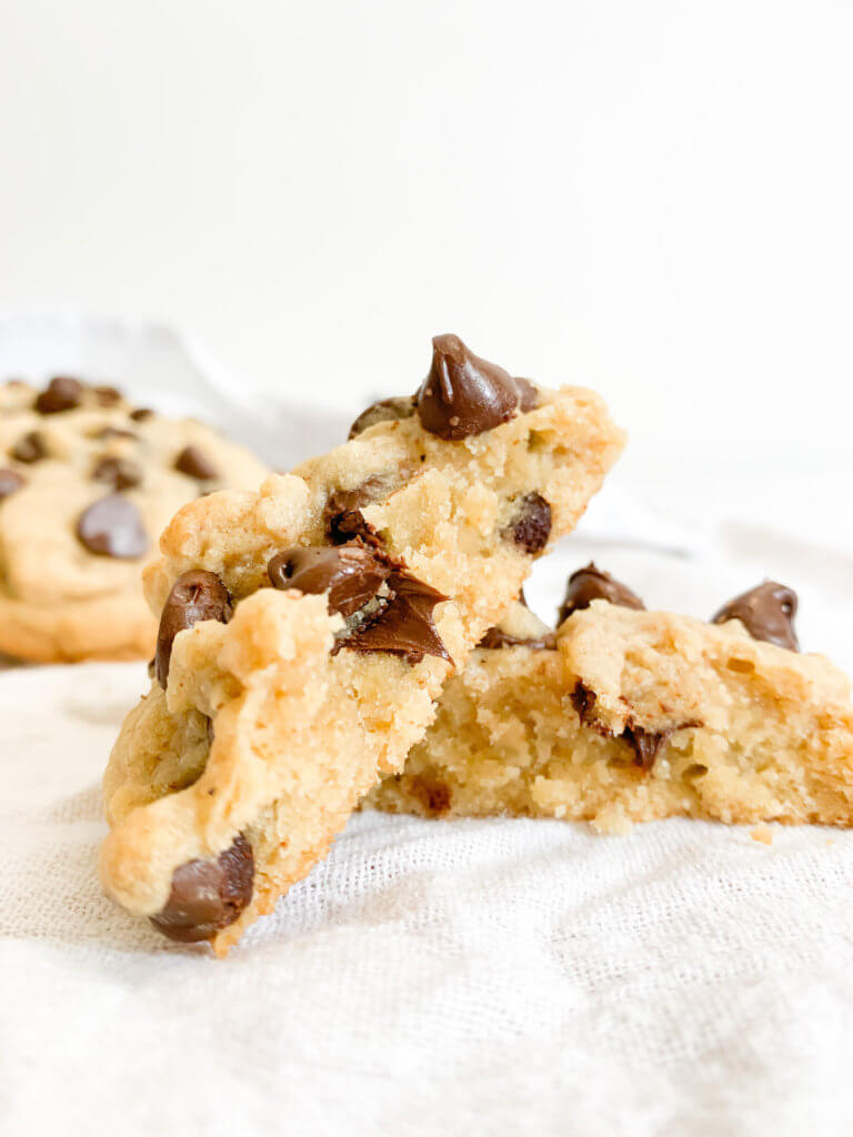Cross section of chocolate chip cookie with gooey center and chocolate melting out