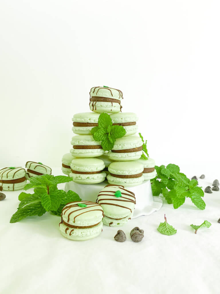 Tower of peppermint cocoa macarons with mint leaves and chocolate chips