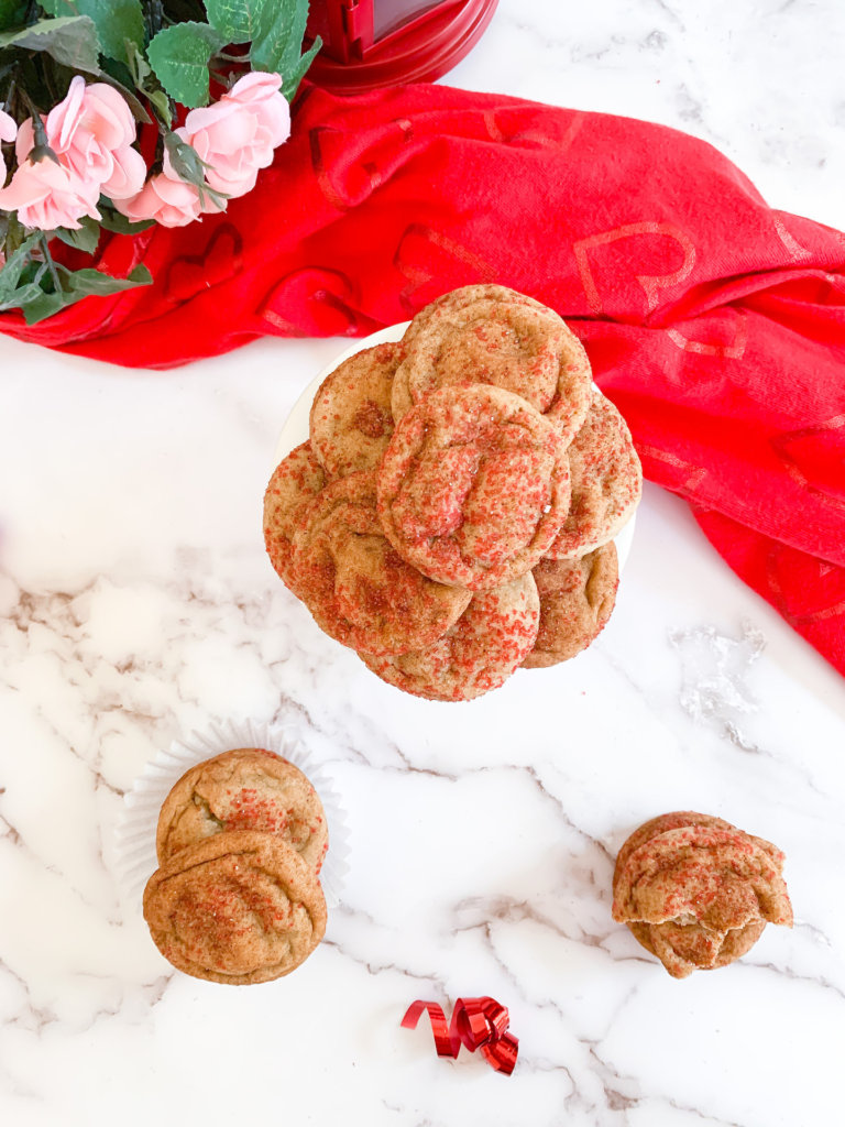 red hot snickerdoodles in stacks on a white counter with a valentine's dish towel.