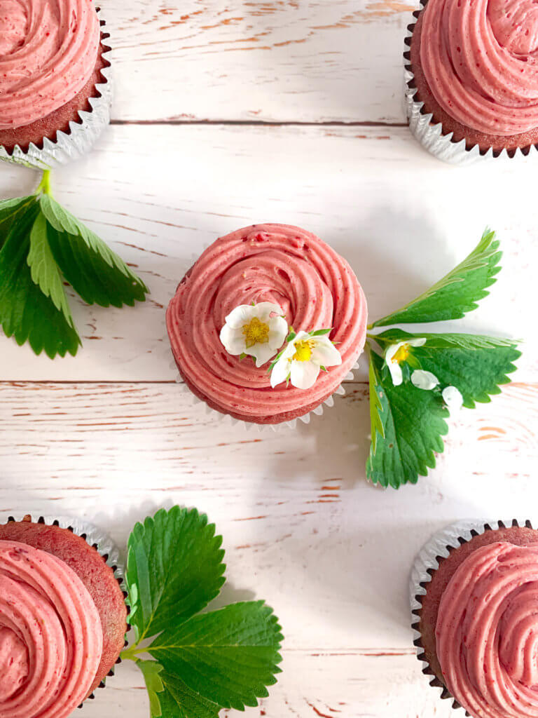 strawberry cupcakes on a whitewashed wood plank surface