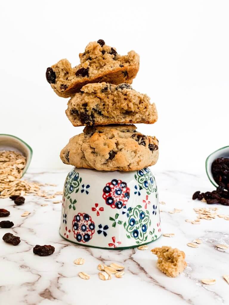 oatmeal raisin cookies for two stacked on a hand painted measuring cup