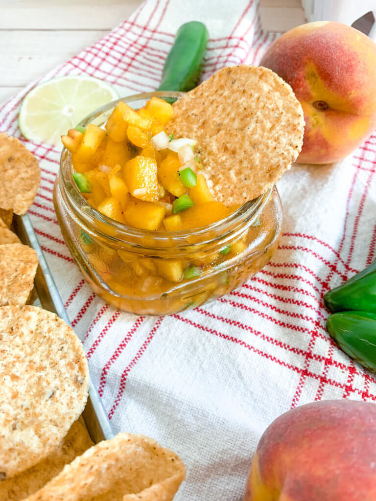 spicy peach salsa with a tortilla chip in it