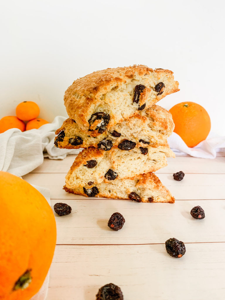 Stack of 4 cranberry orange scones with dried cranberries, oranges, and cuties
