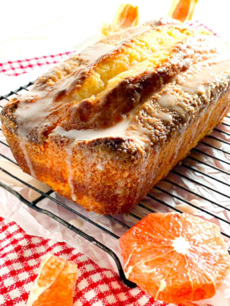 the front corner of a grapefruit pound cake with icing dripping down the side