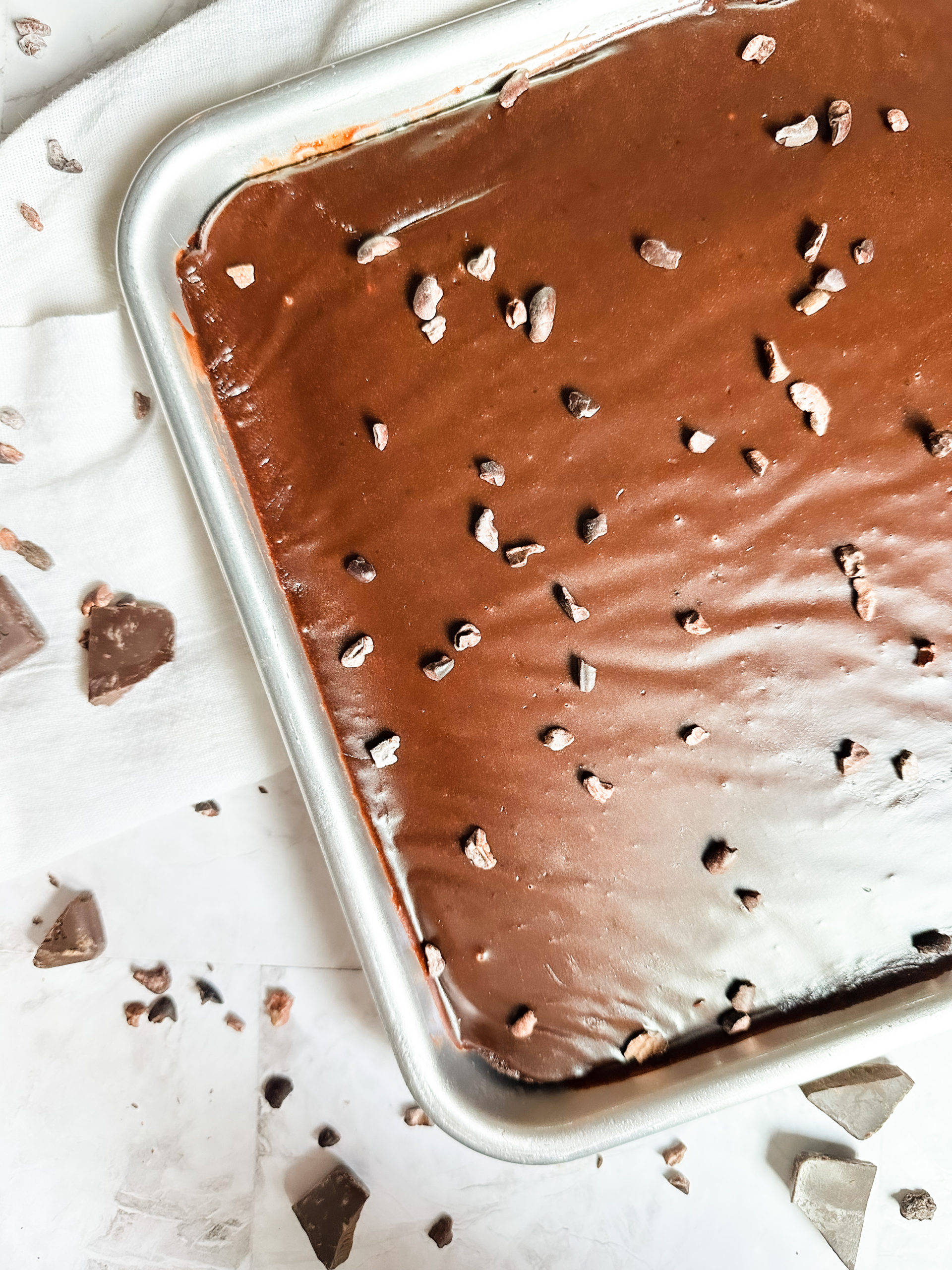 close up of Texas Sheet Cake in a quarter sheet pan with cocoa nibs
