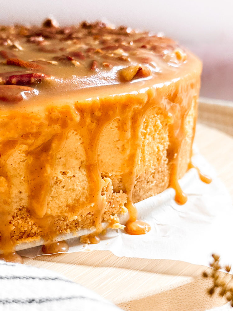 Close up of pecan caramel dripping down the side of pumpkin cheesecake.